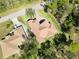 Aerial view displays a charming home featuring a terracotta roof, a brick driveway, and surrounded by greenery at 23117 Hammond Ave, Port Charlotte, FL 33954