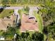 Stunning aerial view of a home with a terracotta roof, a brick driveway, and a well-manicured lawn at 23117 Hammond Ave, Port Charlotte, FL 33954