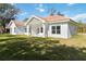 The home's backyard features a covered porch with a sprawling green lawn and manicured landscaping at 23117 Hammond Ave, Port Charlotte, FL 33954