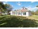 The home's backyard features a covered porch with a sprawling green lawn and manicured landscaping at 23117 Hammond Ave, Port Charlotte, FL 33954