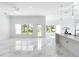 Bright open living room with a fan and windows showcasing outdoor views, next to a kitchen island at 23117 Hammond Ave, Port Charlotte, FL 33954