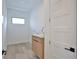 Bright laundry room with wood look floors, a small window, and a sink with stylish cabinets at 2345 Oak Ter, Sarasota, FL 34231