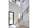 Bright foyer with wood stairs, modern railings, a chandelier, and a glass-paneled front door at 2345 Oak Ter, Sarasota, FL 34231