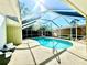 Screened-in pool area with ample seating and beautiful green scenery at 2375 Riverwood Pines Dr, Sarasota, FL 34231