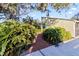 Landscaped side yard showcasing a brick pathway amidst lush greenery leading to the home's entrance at 2375 Riverwood Pines Dr, Sarasota, FL 34231