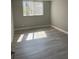 This bedroom features gray wood flooring, light gray walls, and natural light through the window at 2755 Coconut Bay Ln 1K # 119, Sarasota, FL 34237