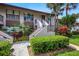 Inviting condo exterior with tropical landscaping and stairs leading to the entrance at 2961 Taywood Mdws # 26, Sarasota, FL 34235