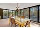 Bright dining area with a unique yellow table, modern chandelier, and views of the lush outdoor landscaping and pool at 3026 Mayflower St, Sarasota, FL 34231