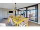 Elegant dining area featuring a modern chandelier, yellow dining set, and a view through sliding glass doors at 3026 Mayflower St, Sarasota, FL 34231