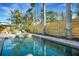 Lush landscaping surrounds the pool and spa featuring a sunbathing deck and privacy fence at 3026 Mayflower St, Sarasota, FL 34231