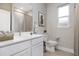 Bright bathroom features a white vanity, large mirror, and bathtub shower at 3200 California Ter, North Port, FL 34291