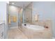 Bright bathroom features a soaking tub, glass shower, and tiled flooring at 3404 79Th Street W Cir # 301, Bradenton, FL 34209