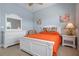 Bright bedroom with orange bedspread, a white dresser, and beach-themed decor at 3404 79Th Street W Cir # 301, Bradenton, FL 34209