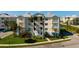 Exterior of a modern condominium featuring private balconies, tropical landscaping, and ample parking at 3404 79Th Street W Cir # 301, Bradenton, FL 34209