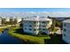 A condo building with a metal roof is surrounded by mature landscaping and a lake view at 3404 79Th Street W Cir # 301, Bradenton, FL 34209