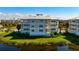 Condo building featuring balconies, metal roof, lush greenery, and picturesque pond views at 3404 79Th Street W Cir # 301, Bradenton, FL 34209