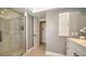 Clean bathroom features a glass shower, tiled walls, a white vanity, and storage at 3530 Flores Ave, Sarasota, FL 34239