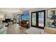 Bright living room with a black grand piano, ceiling fan, and glass doors leading to the outside at 3530 Flores Ave, Sarasota, FL 34239