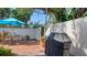 Private patio featuring a brick surface, a dining set under a blue umbrella, and a built-in gas grill at 3530 Flores Ave, Sarasota, FL 34239