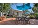 Outdoor patio featuring a brick surface, a patio table, and lush landscaping at 3530 Flores Ave, Sarasota, FL 34239