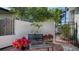 Cozy side yard featuring a seating area with a bench, table, potted plants, and a gate to the front of the home at 3530 Flores Ave, Sarasota, FL 34239