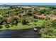 Scenic aerial view highlighting the lake, dock, and community buildings with red-tiled roofs at 4061 Crockers Lake Blvd # 2611, Sarasota, FL 34238