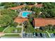 Aerial view features the community pool and charming residential buildings with terracotta roofs at 4061 Crockers Lake Blvd # 2611, Sarasota, FL 34238