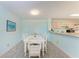 Dining room with a white dining table, carpeted floor, and view into kitchen area at 4061 Crockers Lake Blvd # 2611, Sarasota, FL 34238