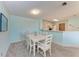 Dining room with white dining table, art, carpeted floor, and view into kitchen at 4061 Crockers Lake Blvd # 2611, Sarasota, FL 34238