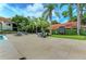 Outdoor pool and patio area with lounge chairs and tables, shaded by palm trees providing a great social gathering place at 4061 Crockers Lake Blvd # 2611, Sarasota, FL 34238