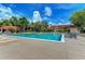 Inviting community pool with lounge chairs, lush landscaping, and a clear blue sky, perfect for relaxation and recreation at 4061 Crockers Lake Blvd # 2611, Sarasota, FL 34238