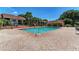 Community pool surrounded by brick paving and trees, offering a refreshing retreat for residents to enjoy at 4061 Crockers Lake Blvd # 2611, Sarasota, FL 34238