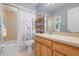 Bathroom showcasing a shower-tub combo, wooden vanity, and tiled floors, plus blue accent walls at 4411 Violet Ave, Sarasota, FL 34233