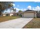 Single-story home with a long driveway, attached garage, and well-maintained lawn at 4411 Violet Ave, Sarasota, FL 34233