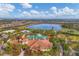 An aerial view of a community clubhouse, swimming pool and golf course, surrounded by palm trees and a lake at 4543 Terrazza Ct, Lakewood Ranch, FL 34211