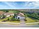 Beautiful aerial view of a home with a tile roof, lush landscaping, and views of the adjacent golf course and lake at 4543 Terrazza Ct, Lakewood Ranch, FL 34211