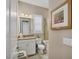 Neutral bathroom features a granite-topped vanity, framed mirror, and tile floors at 4543 Terrazza Ct, Lakewood Ranch, FL 34211