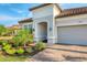 Close up of a home exterior featuring a tile roof, brick paved driveway, arched entryway, and manicured landscaping at 4543 Terrazza Ct, Lakewood Ranch, FL 34211