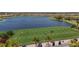 Golf course scene shows players on the green near a pond, with golf carts and palm trees at 4543 Terrazza Ct, Lakewood Ranch, FL 34211