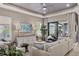 Bright living room featuring tray ceiling, neutral colors, and sliding glass doors to the outdoor living area at 4543 Terrazza Ct, Lakewood Ranch, FL 34211