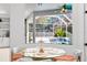 Bright breakfast nook featuring a glass-top table and views of the screened pool area at 5063 Timber Chase Way, Sarasota, FL 34238