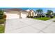 Expansive driveway leading to a three-car garage, surrounded by lush landscaping at 5063 Timber Chase Way, Sarasota, FL 34238