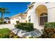 Inviting front entrance with arched doorway, lush landscaping, and a well-maintained lawn at 5063 Timber Chase Way, Sarasota, FL 34238