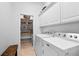 Clean laundry room featuring a washer, dryer, and shelving for organized storage at 5063 Timber Chase Way, Sarasota, FL 34238