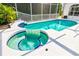 Beautiful pool and spa with blue tile accents, surrounded by a white patio at 5063 Timber Chase Way, Sarasota, FL 34238