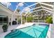 Gorgeous pool with a screened enclosure, surrounded by lush landscaping and patio space at 5063 Timber Chase Way, Sarasota, FL 34238