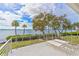 Waterfront balcony with lounge chairs, a white railing, and views of palm trees and blue skies at 55 Tidy Island Blvd, Bradenton, FL 34210