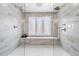 Modern bathroom featuring marble tile, glass enclosure, shower bench, and a window for natural light at 55 Tidy Island Blvd, Bradenton, FL 34210