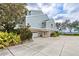 Stylish elevated two-story home with light blue siding, meticulously landscaped yard and spacious paved driveway at 55 Tidy Island Blvd, Bradenton, FL 34210