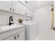 Laundry room with modern appliances, white cabinetry, and a utility sink at 55 Tidy Island Blvd, Bradenton, FL 34210